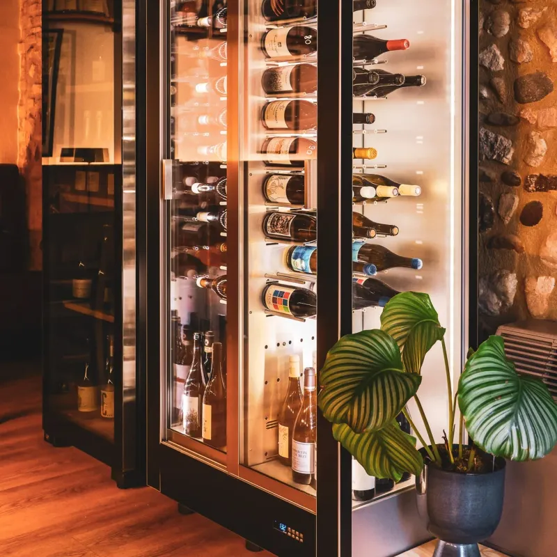 La cantinetta dei vini illuminata tra le pareti in pietra