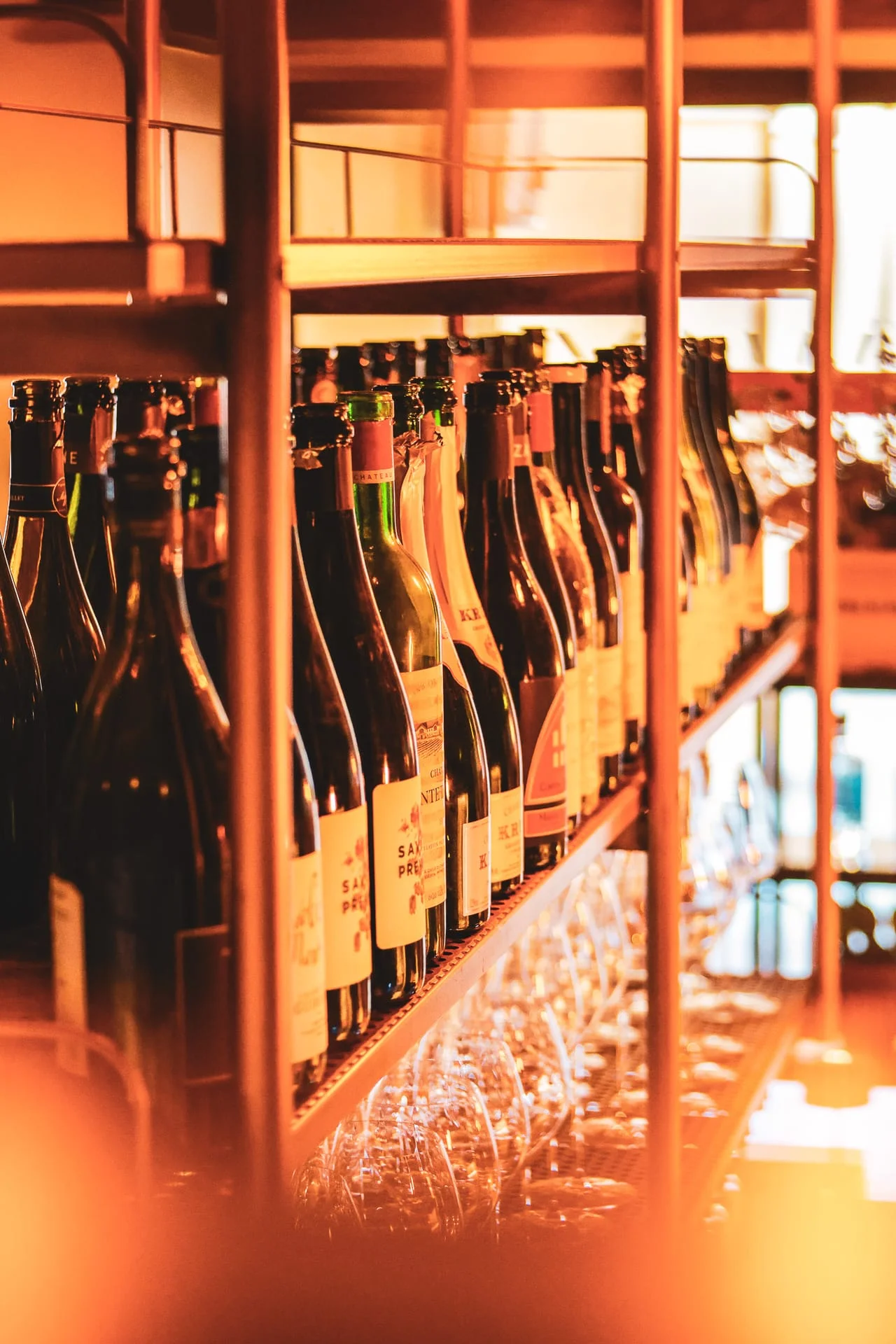 Bottiglie di vino allineate sugli scaffali in ferro sopra il bancone